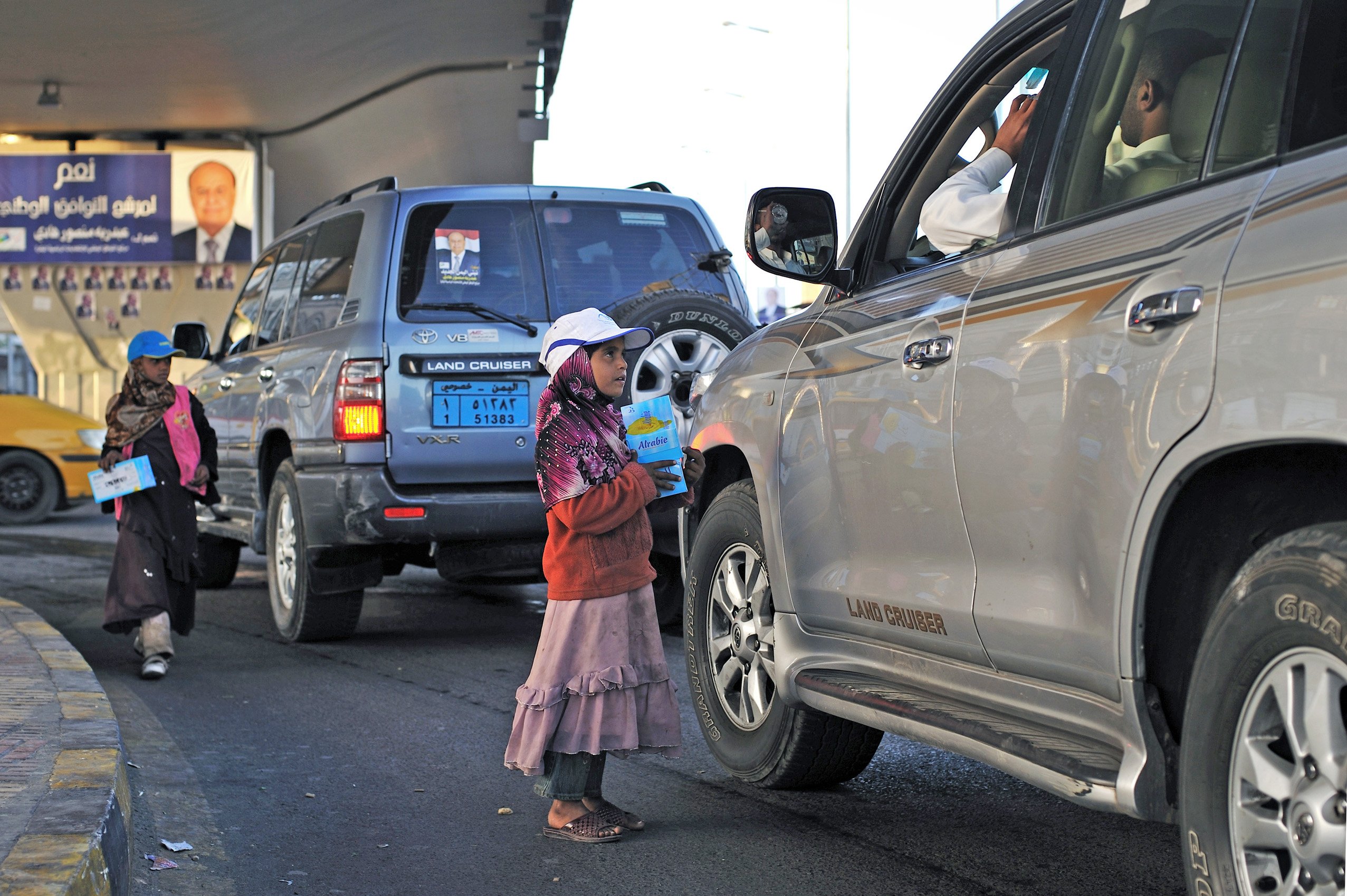 Yasmine Hajiri and her sister sell tissues to passing drivers at an intersection in downtown Sana'a on February 15, 2012. Hajiri's family took her and her sisters out of school so that they could help generate income by selling tissue after the family sto