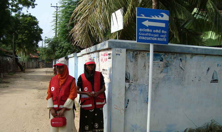 Red Cross workers near a tsunami evacuation sign on 11 April 2012. More than 1 million people were evacuated