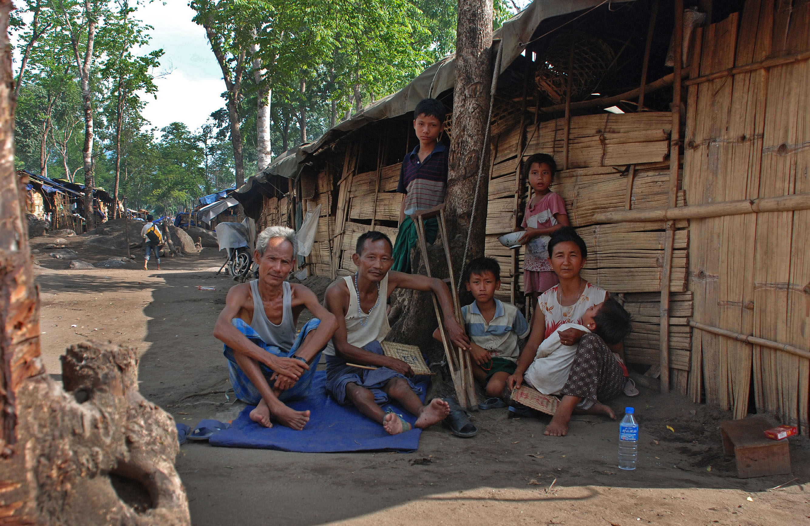 A family outside their shelter at the Je Yang IDP camp in Kachin State. More than 6,500 now call it home