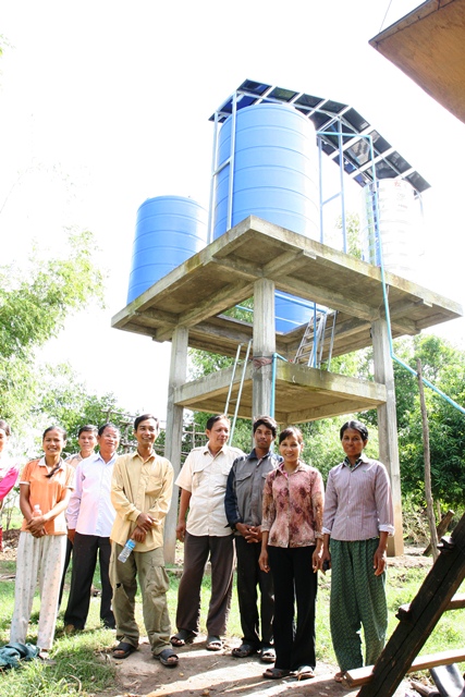 Farmers in front of Bosleav commune's first water user association, posing in front of a solar-powered water pump