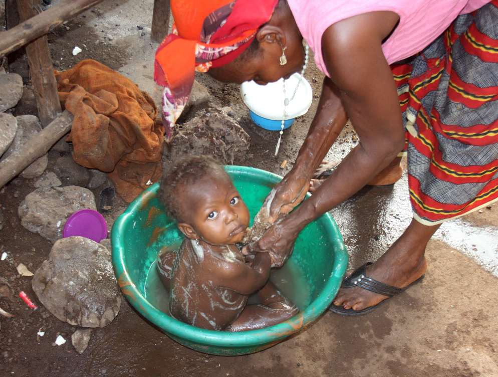 A mother washes her child in Kroo Bay slum in Freetown, where access to basic sanitation is severely limited and cholera outbreaks are regular occurrences