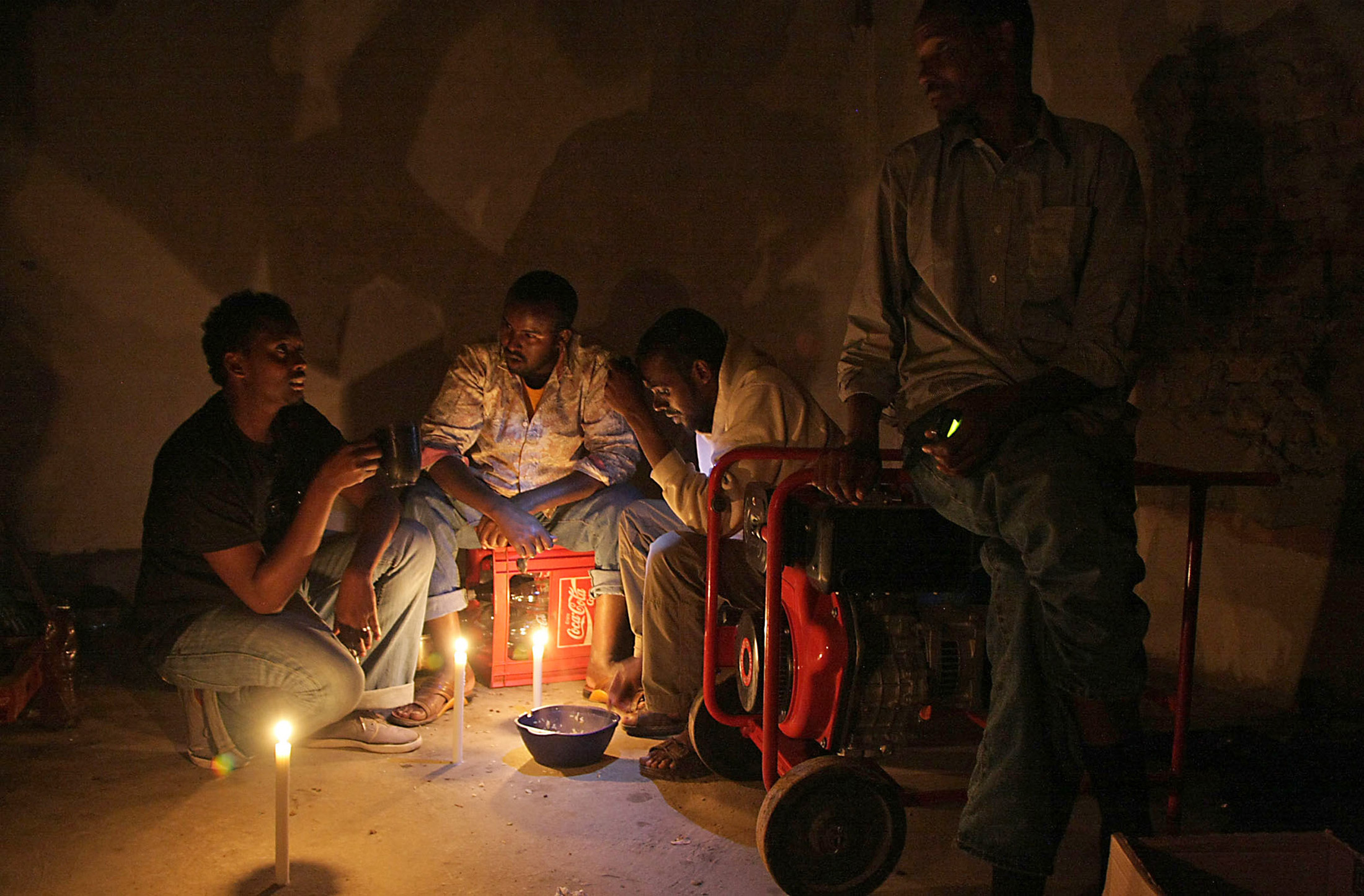 Somali shopkeeper Abdul Abdullah and his three employees share an evening meal in the small living space at the back of the shop