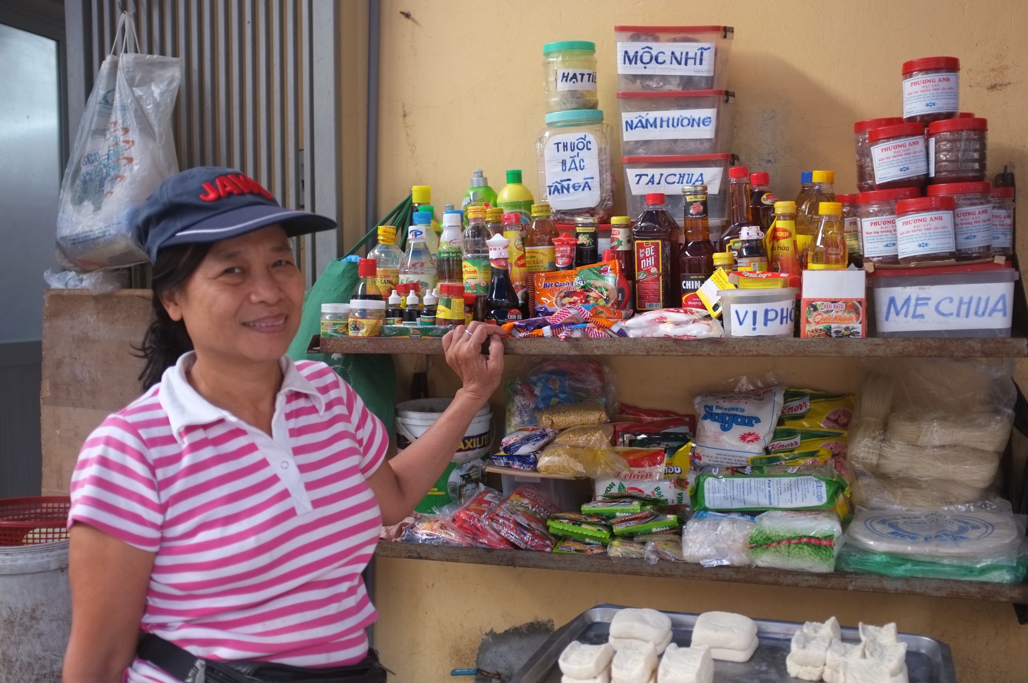 Vendor in Vietnam who displays condiments on sale, but no iodized salt