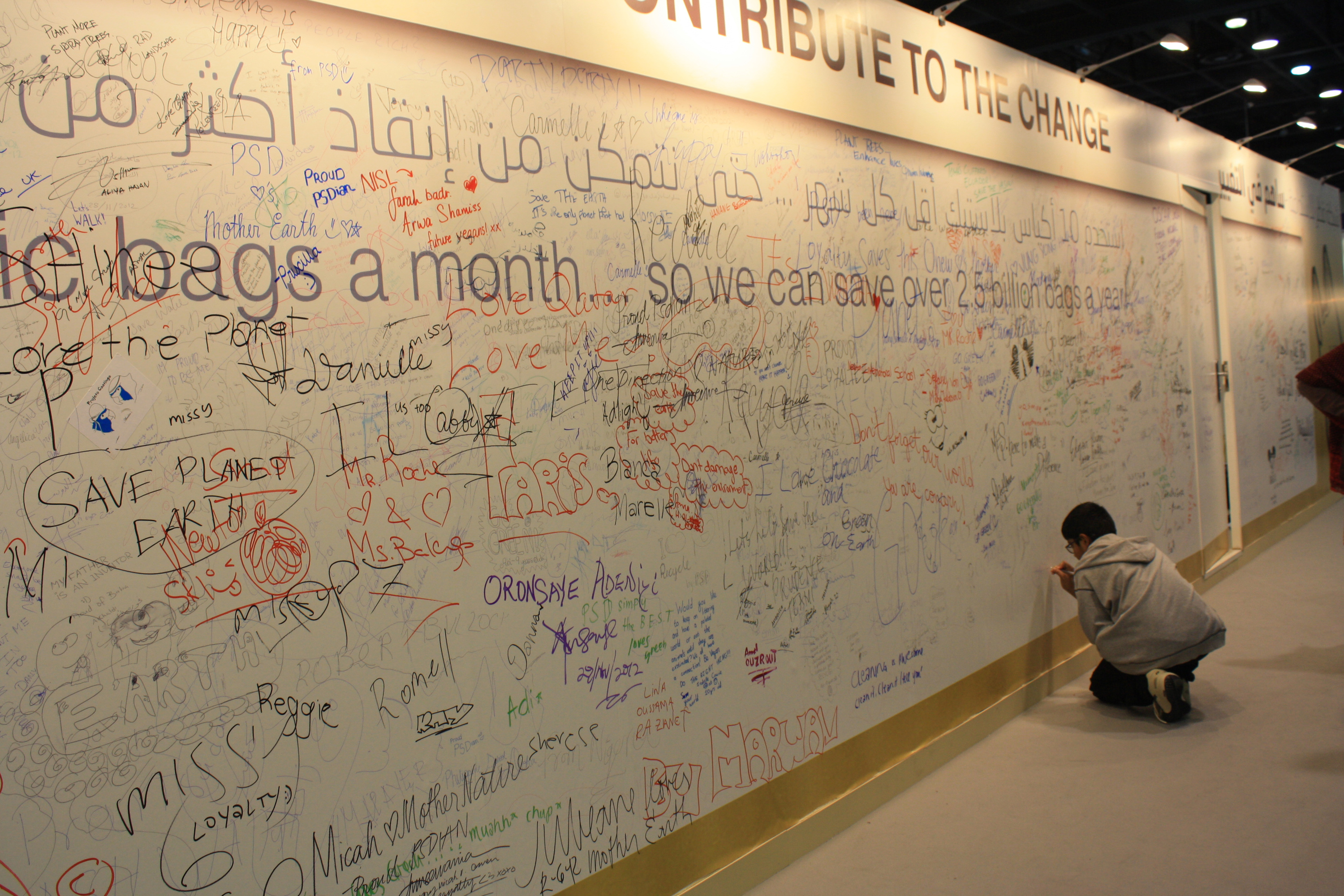 A young boy signs a message to save the planet at the Qatar Sustainability Expo organised to run concurrently with the climate change talks and create awareness