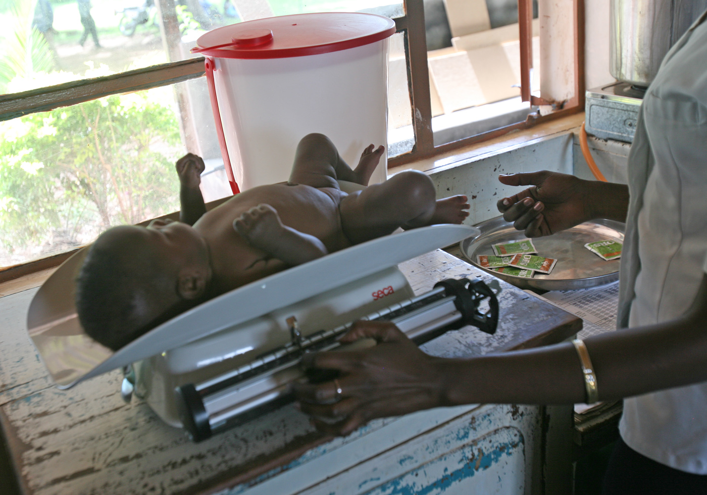 A nurse takes a child’s weight at a hospital in western Kenya