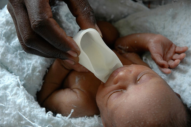 Newborn infant being cup fed by a nurse