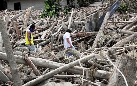Survivors pass through their devastated village in the southern town of New Bataan, Mindanao, following Typhoon Bopha, which destroyed entire tracts of farms in December 2012