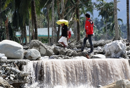 Farmers return to their farming village in the town of New Bataan in the southern Philippines that was devastated by Typhoon Bopha in December 2012