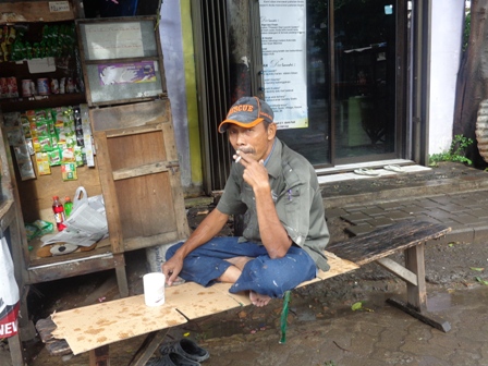 A man enjoys a cigarette on the streets of Jakarta