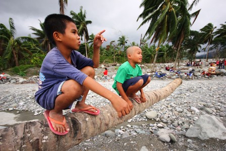 Two boys survey the damage in Mindanao's Compostela Valley in the wake of Typhoon Bopha which struck the area on 4 December 2012. Some 6.2 million people were affected