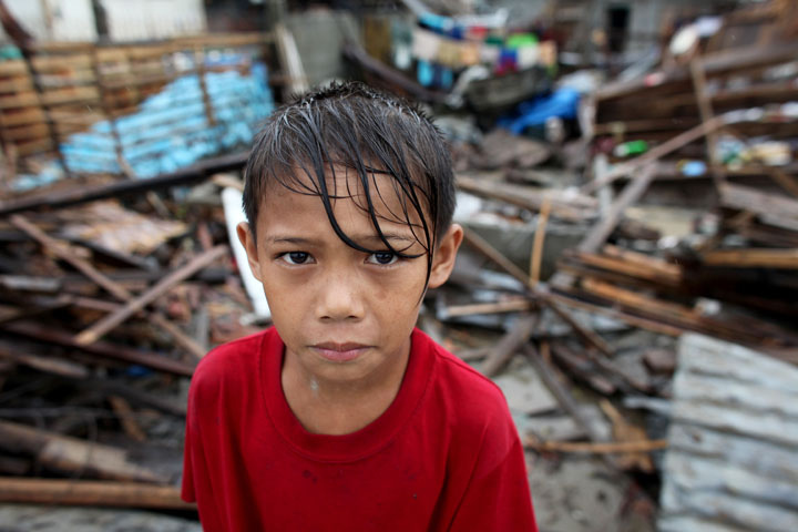 GBoy Quizon, 9, stands amidst the rubble in their village after super typhoon Pablo hit Compostela Valley last December 2012