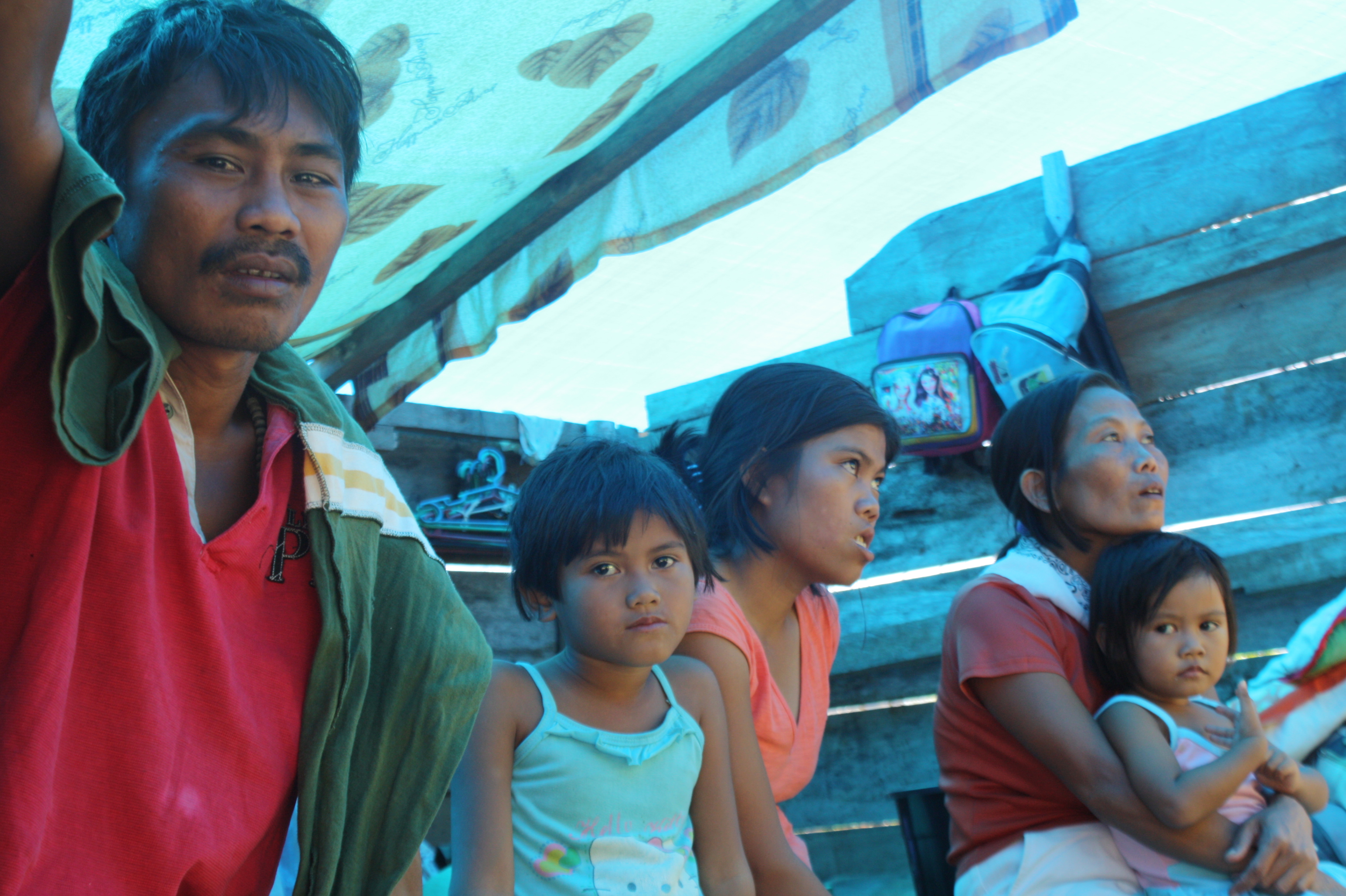 Families in Panansalan, a barangay hit by Typhoon Bopha/Pablo on 4 December 2012, continue living in their damaged home two months afterward