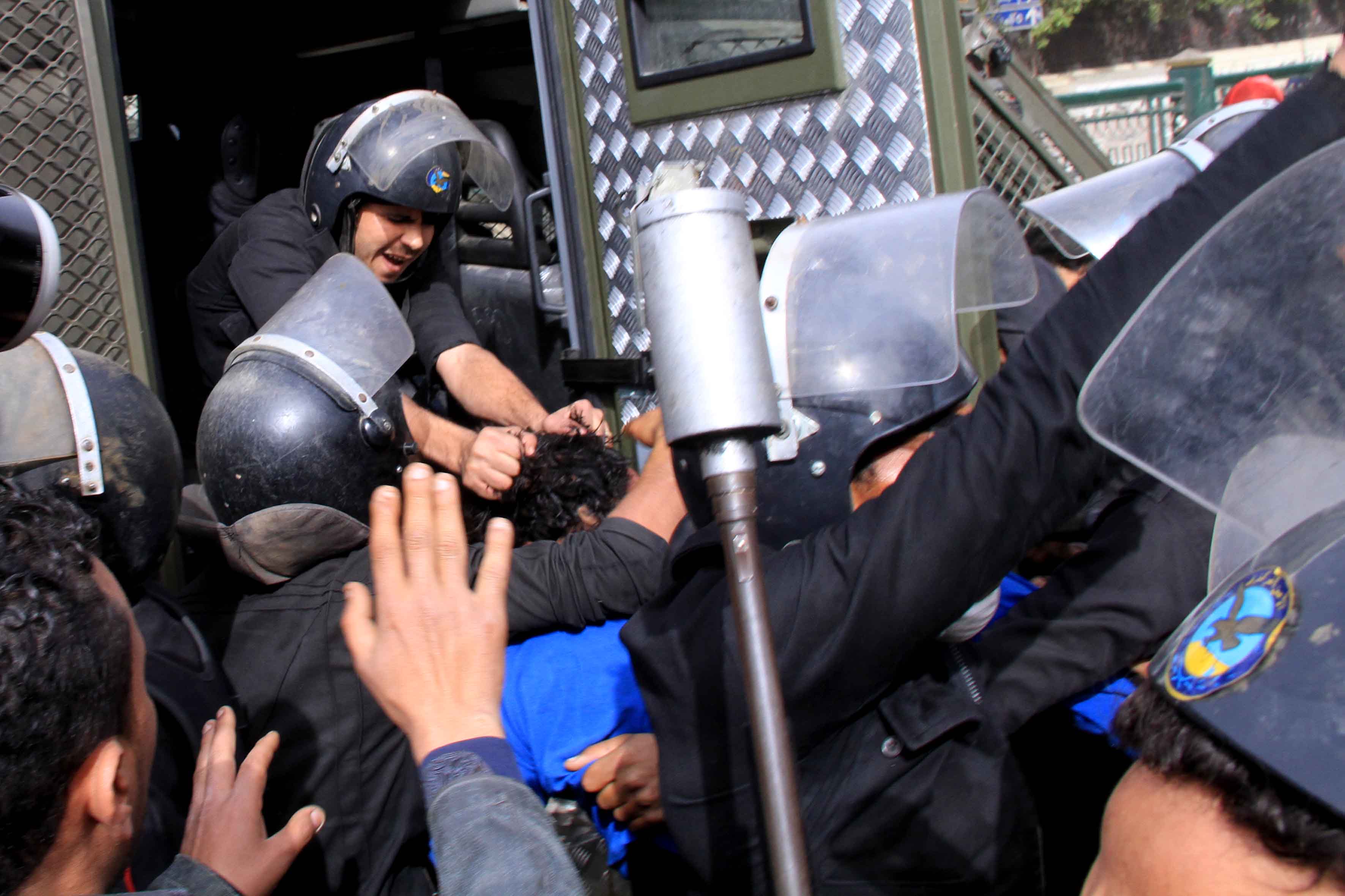 On the second anniversary of the 2011 revolution, policemen in Egypt pull one protestor by the hair after arresting him in central Cairo, the scene of violent clashes between policemen guarding state institutions and hotels and protestors