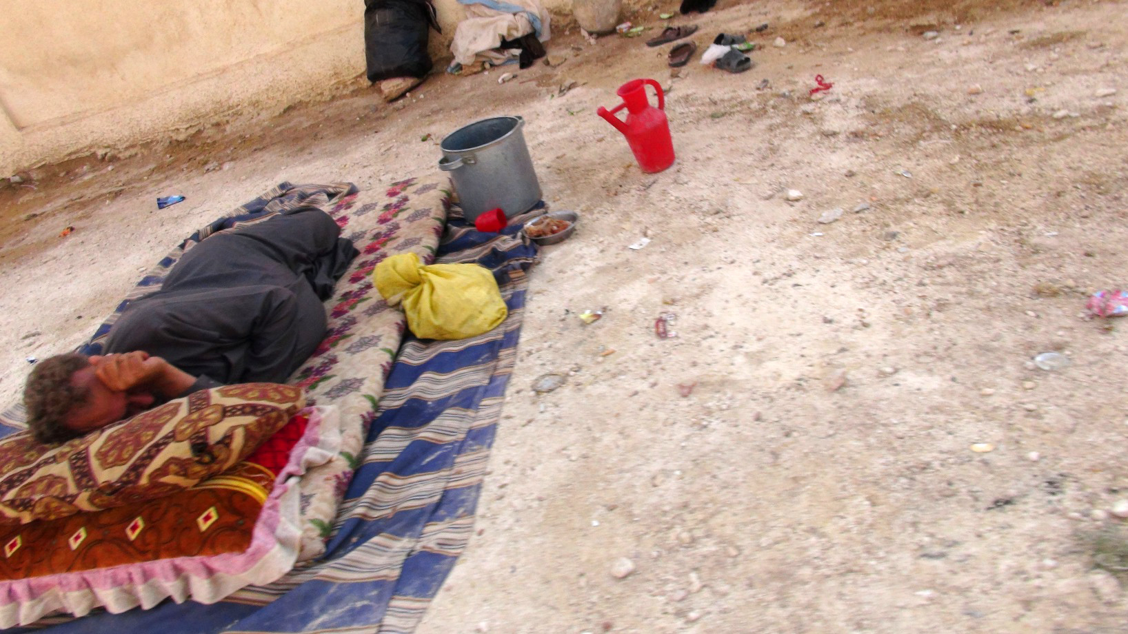 A displaced man sleeps in Syria. Many communal shelters are poorly equipped, lacking furniture and access to basic hygiene