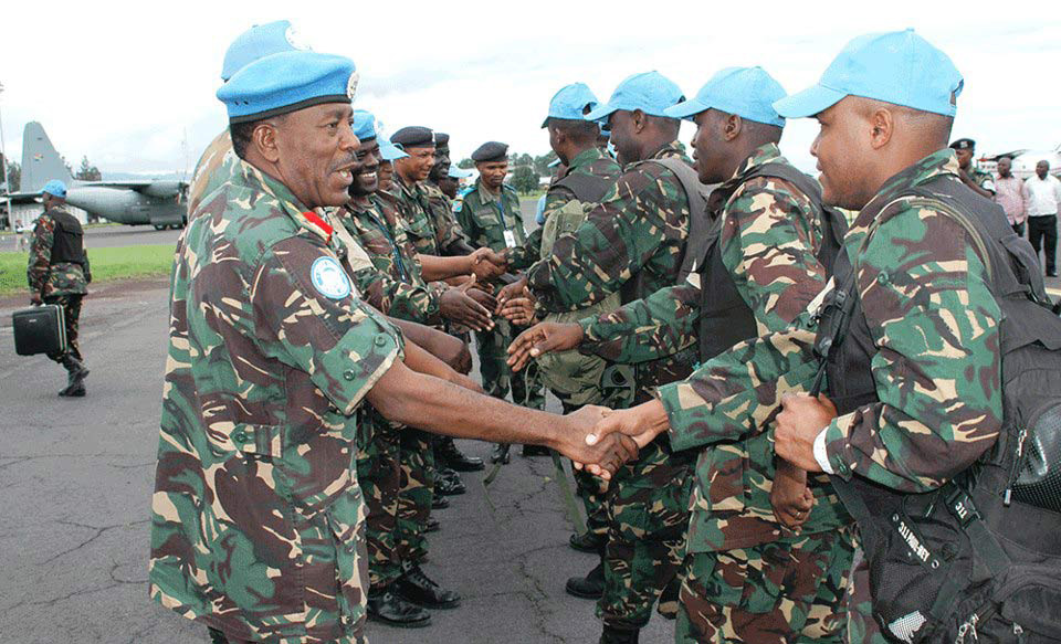 Tanzanian UN Intervention Brigade commander Brig-Gen James Makibolwa shakes hands with Tanzanian troops