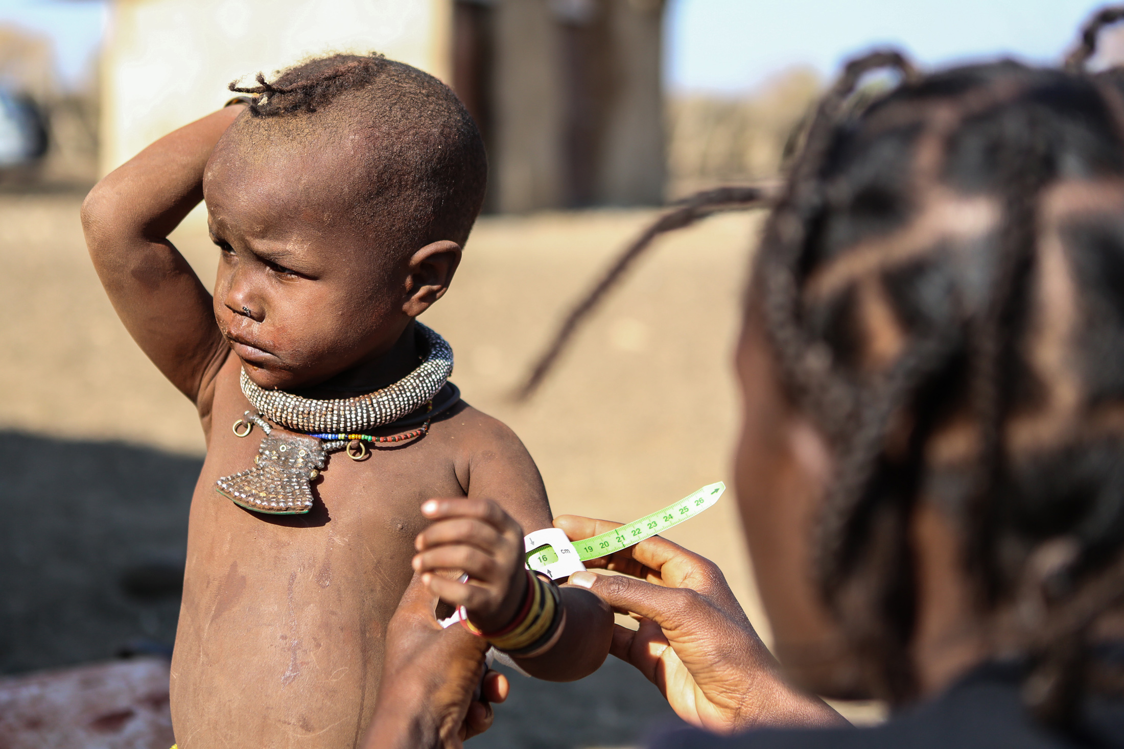 Health extension worker, Julita Hamukuaja screens a child for malnutrition in drought-hit northwestern Namibia's Opuwo District