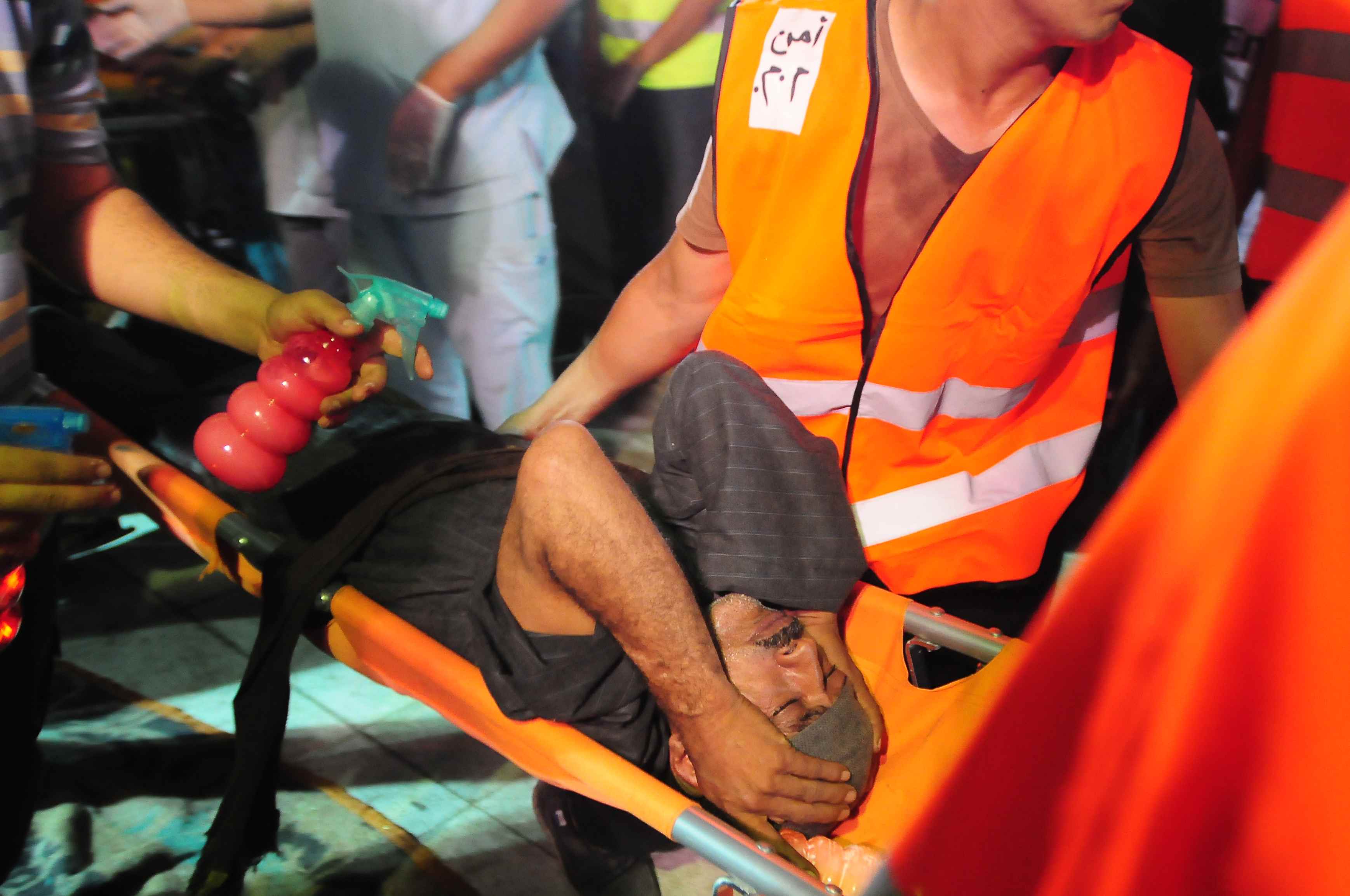 An injured Morsi supporter is carried away following clashes with policemen in the east of Cairo in the early hours (27 July 2013)