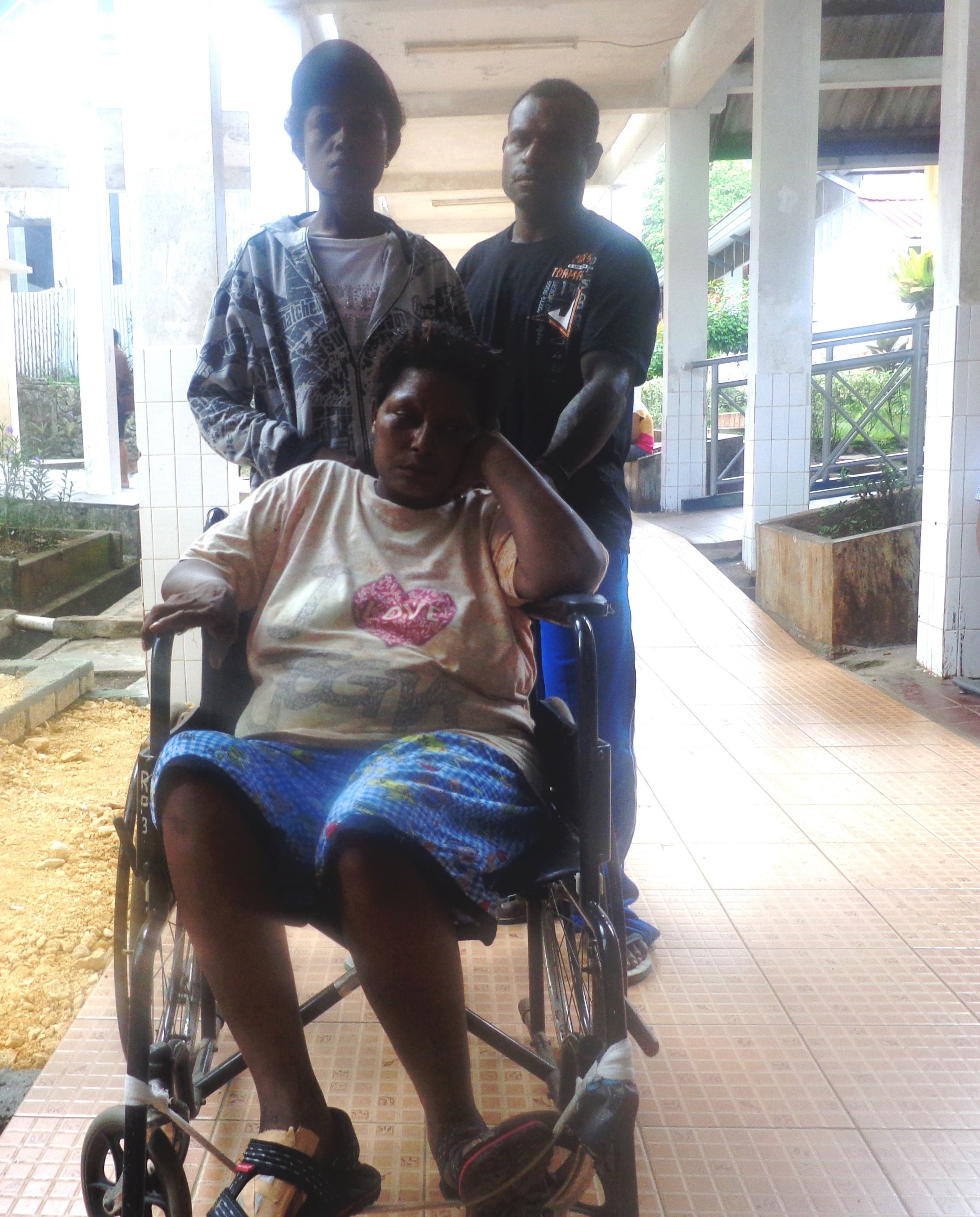 Indonesian Papuan indigenous persons qualify for health insurance under a recent government program that has swelled patient queues and hospital waiting rooms as people like Yusmina Wakum (seated in the wheelchair) take advantage of the near-free treatmen