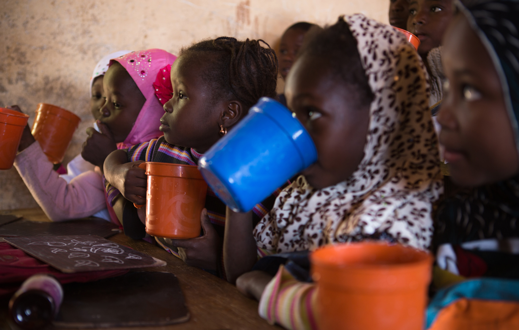 Students eat their first meal of the day in their classroom in Gao, Mali. The World Food Program provides two meals a day to schools in Gao and other conflict-affected cities in northern Mali, such as Timbuktu. The emergency feeding program has seen a ris