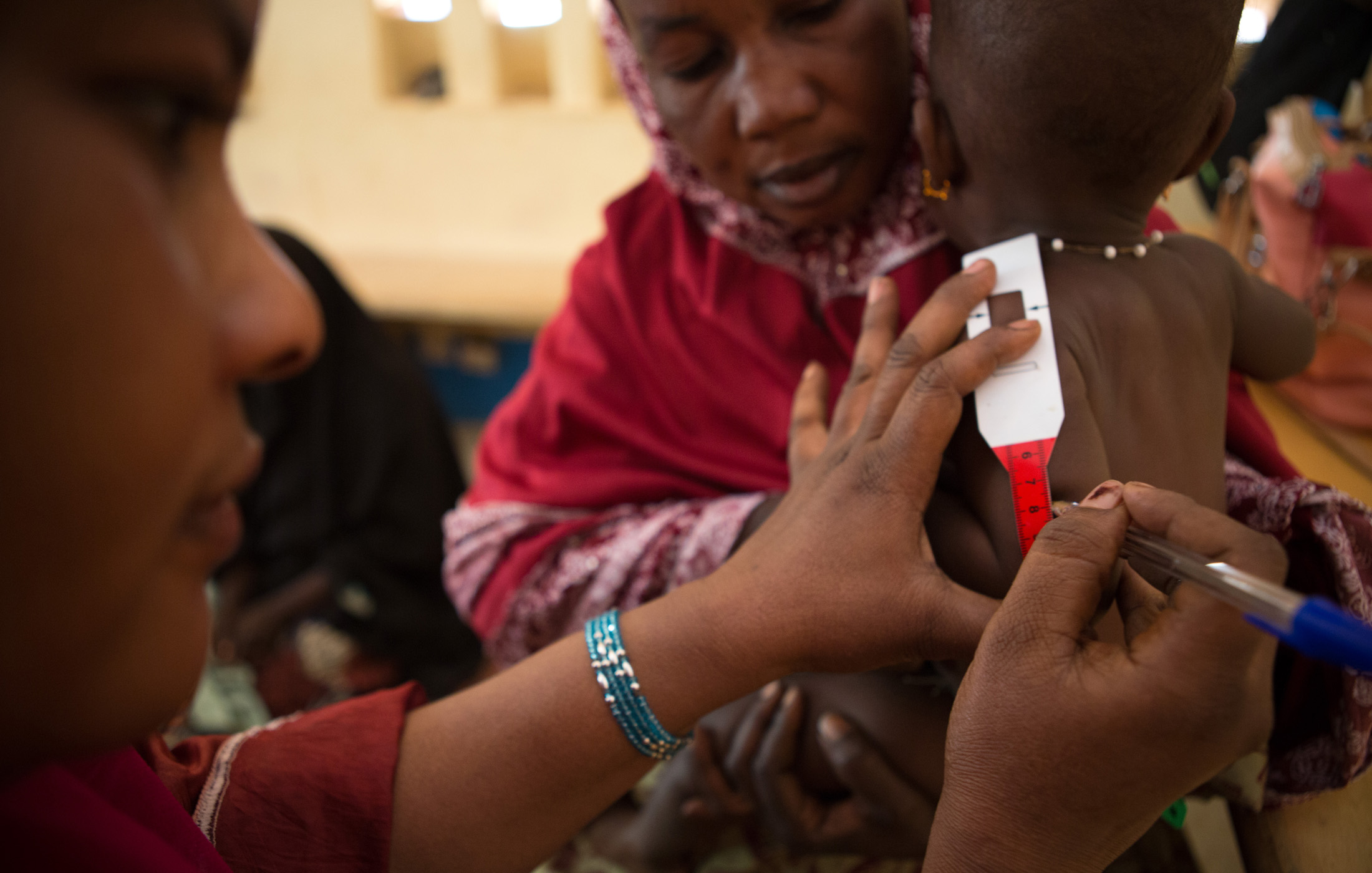 A nurse records a child’s weight and height during a consultation at the referral health center in Gao, Mali. WFP, in partnership with Action Contre la Faim (ACF), provide consultations, care and medication to malnourished children and pregnant women i