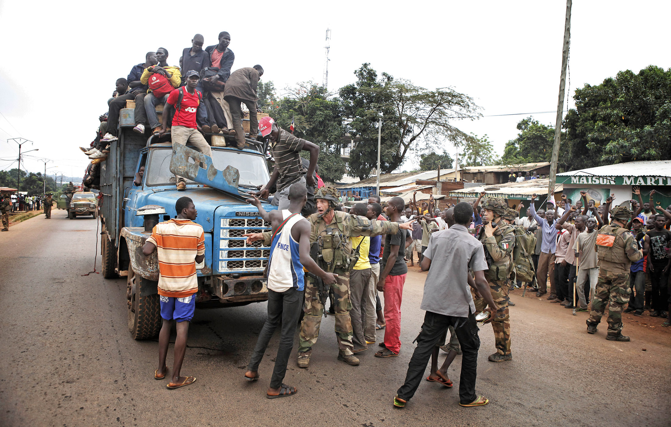 French soldiers protect a convoy of fleeing refugees from an angry mob in the Bangui estate of PK. Many muslims have fled the ongoing violence in Bangui