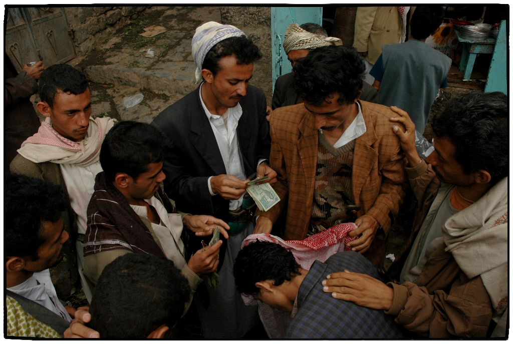 Men exchange money in Yemen. For generic use