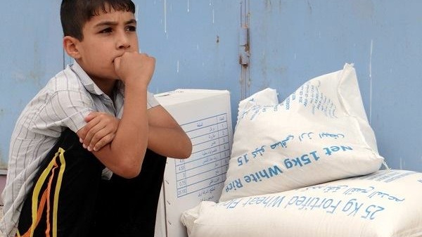 An Iraqi boy receives assistance from the World Food Program (WFP) after flooding in Abu Ghraib in April 2014, caused by militants of the Islamic State of Iraq and the Levant (ISIL) who took control of the Nuaimiyah dam.