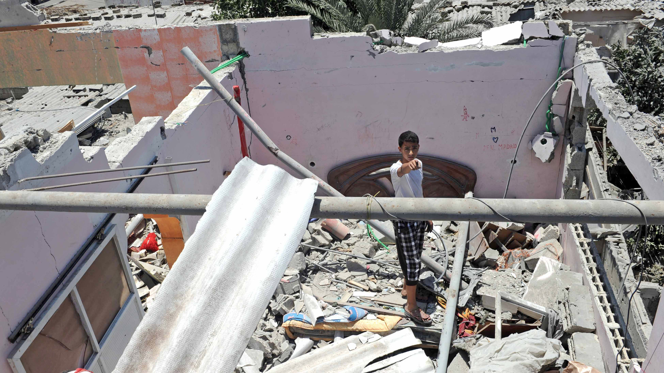 Palestinians inspect the remains of a house which was destroyed during an air strike in Central Bureij refugee camp, in the Middle Area of the Gaza Strip.