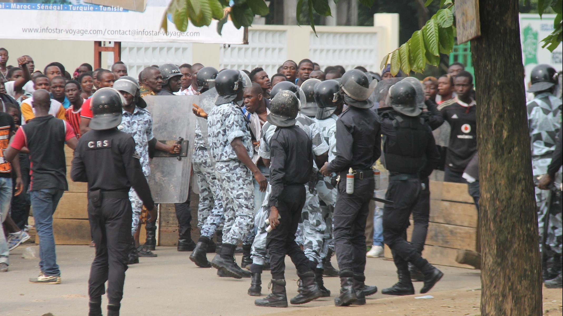 Ivoirian security forces restrain a crowd protesting against the