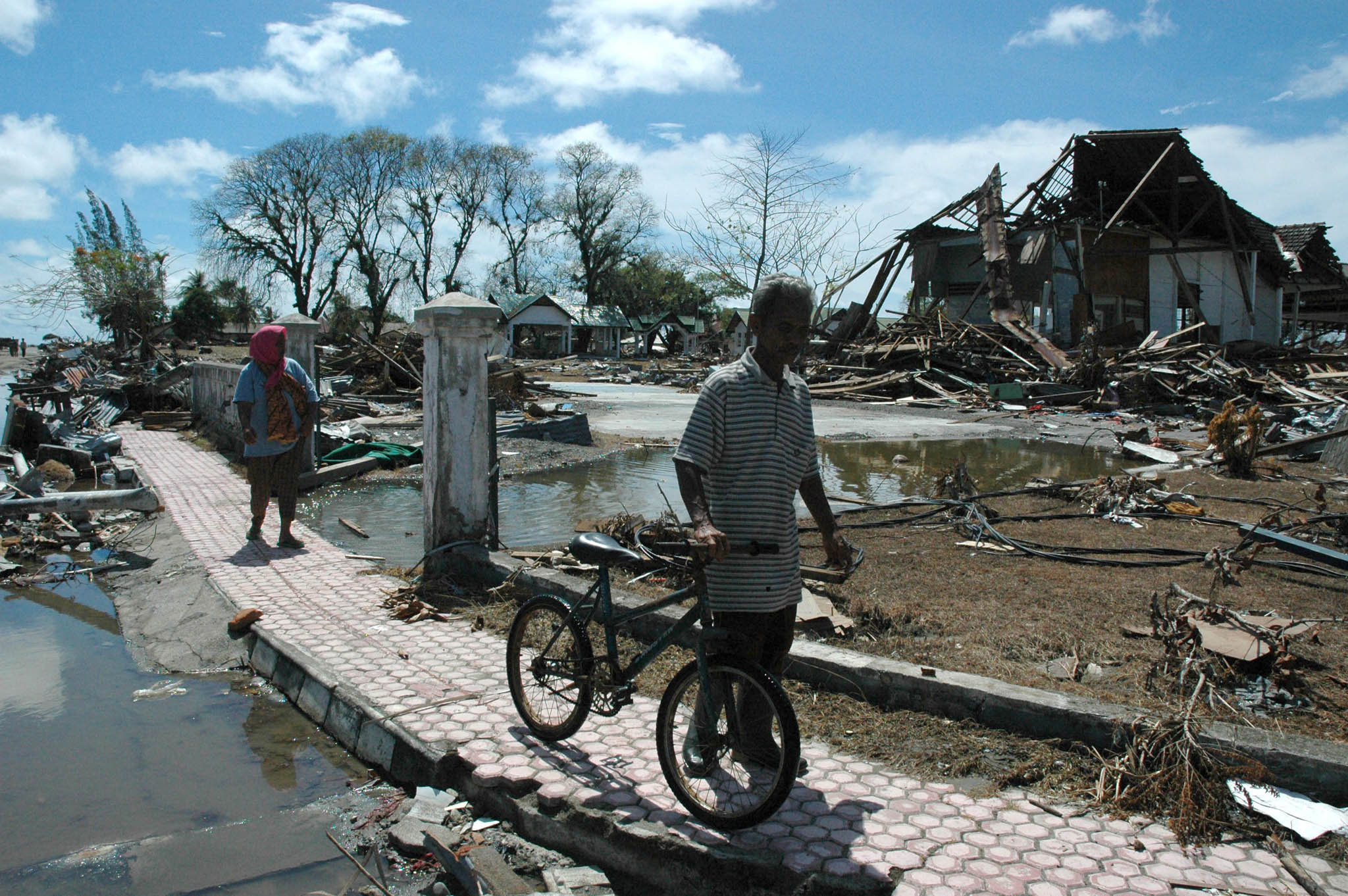 A tsunami survivor walks pass ruins of a building in Meulaboh, West Aceh (File photo 2004)