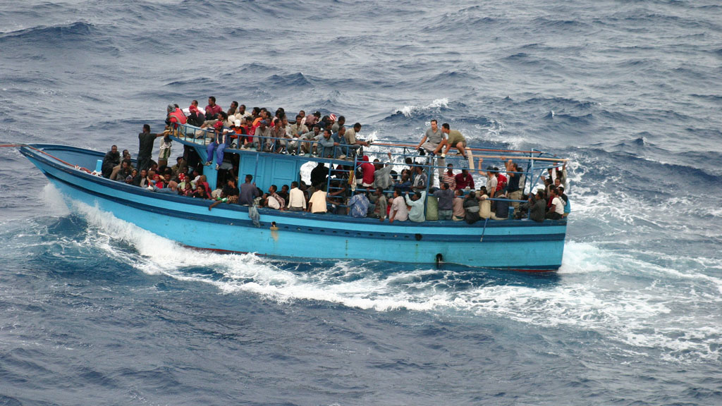 A boat carrying African asylum seekers and migrants in the Mediterranean Sea between Africa and Italy