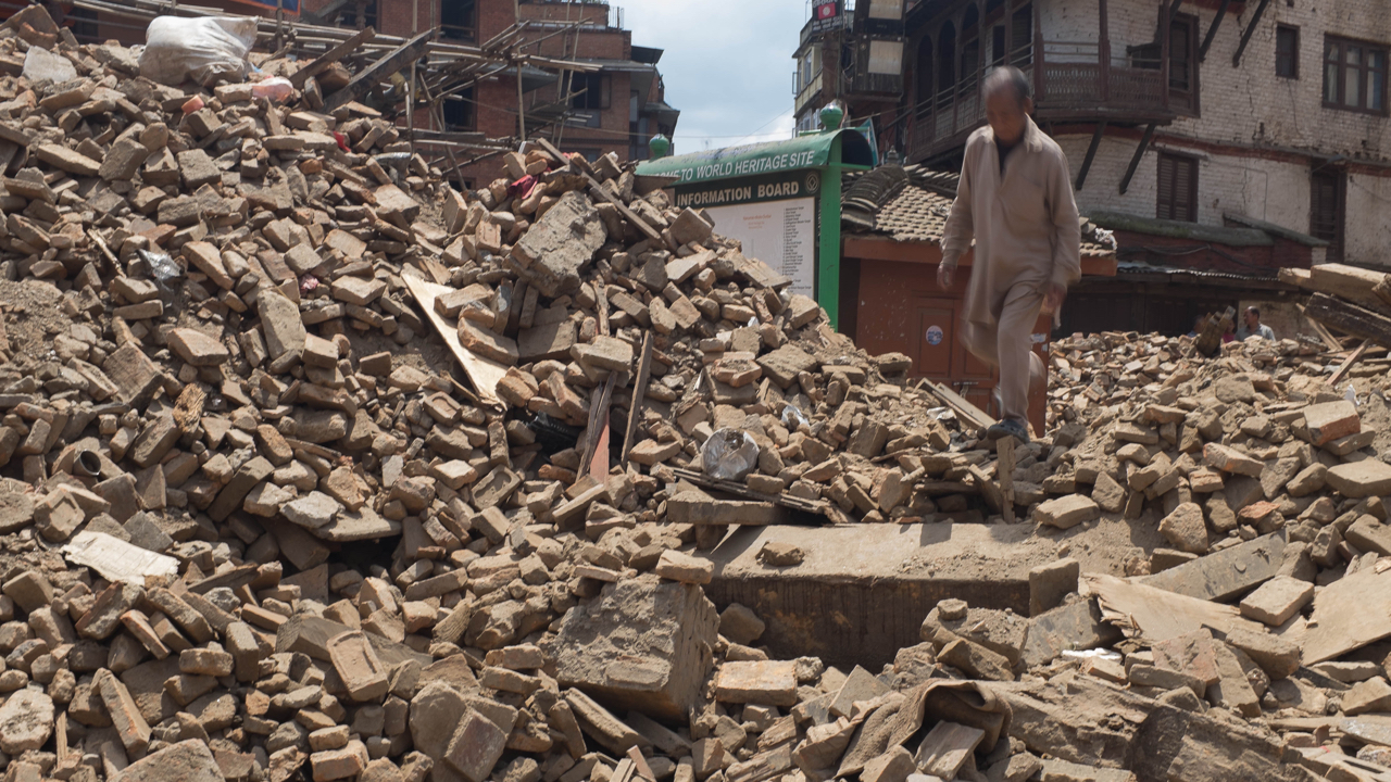 A man walks on top of debris from collapsed monuments in Basantapur in Central Kathmandu on 27 April 2015 in Kathmandu, Nepal. Nepal was struck by a powerful earthquake on 25 April