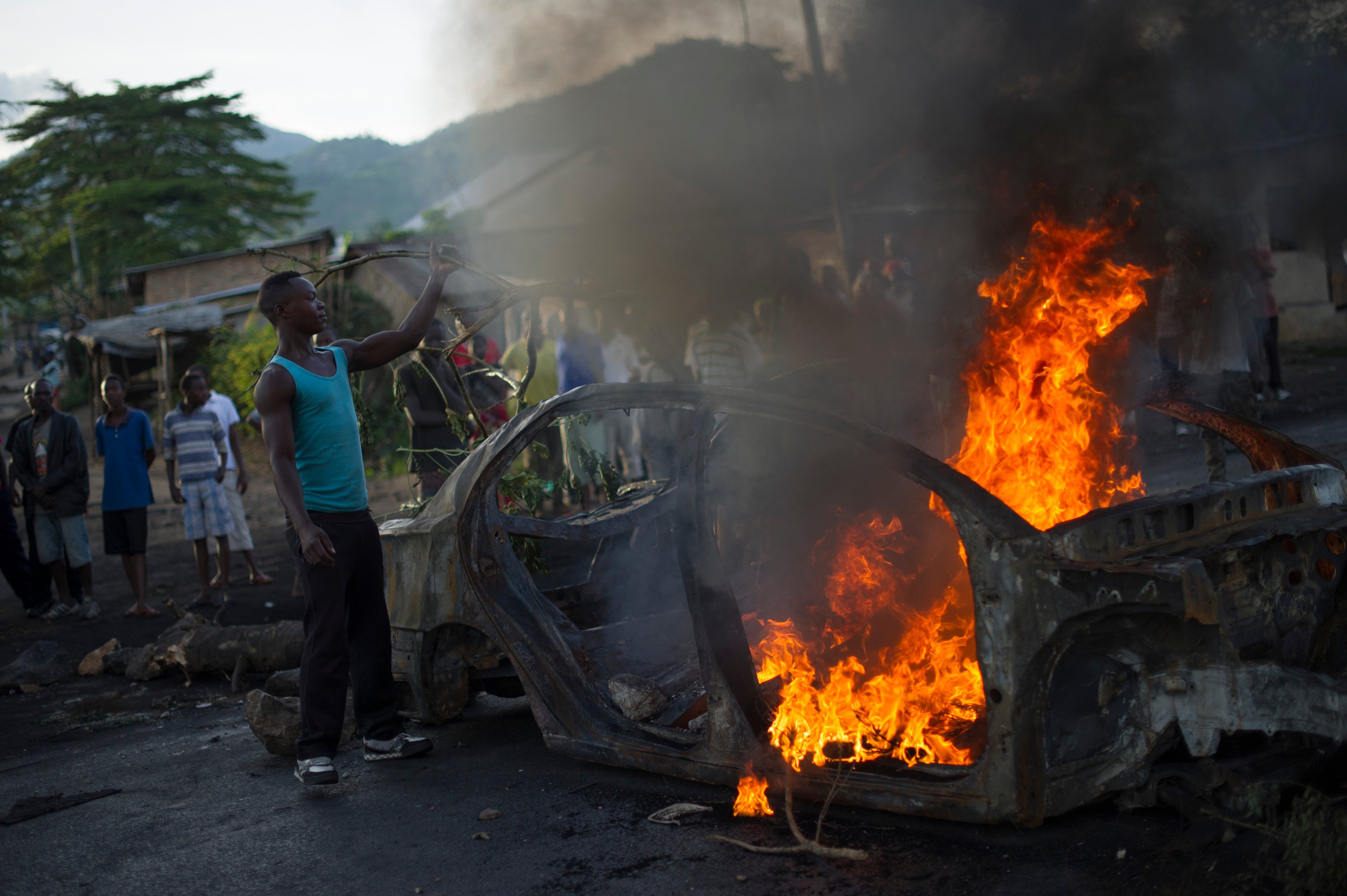 A protestor fuels a burning barricade in the Musaga neighbourhood of Bujumbura, Burundi, on May 4, 2015.