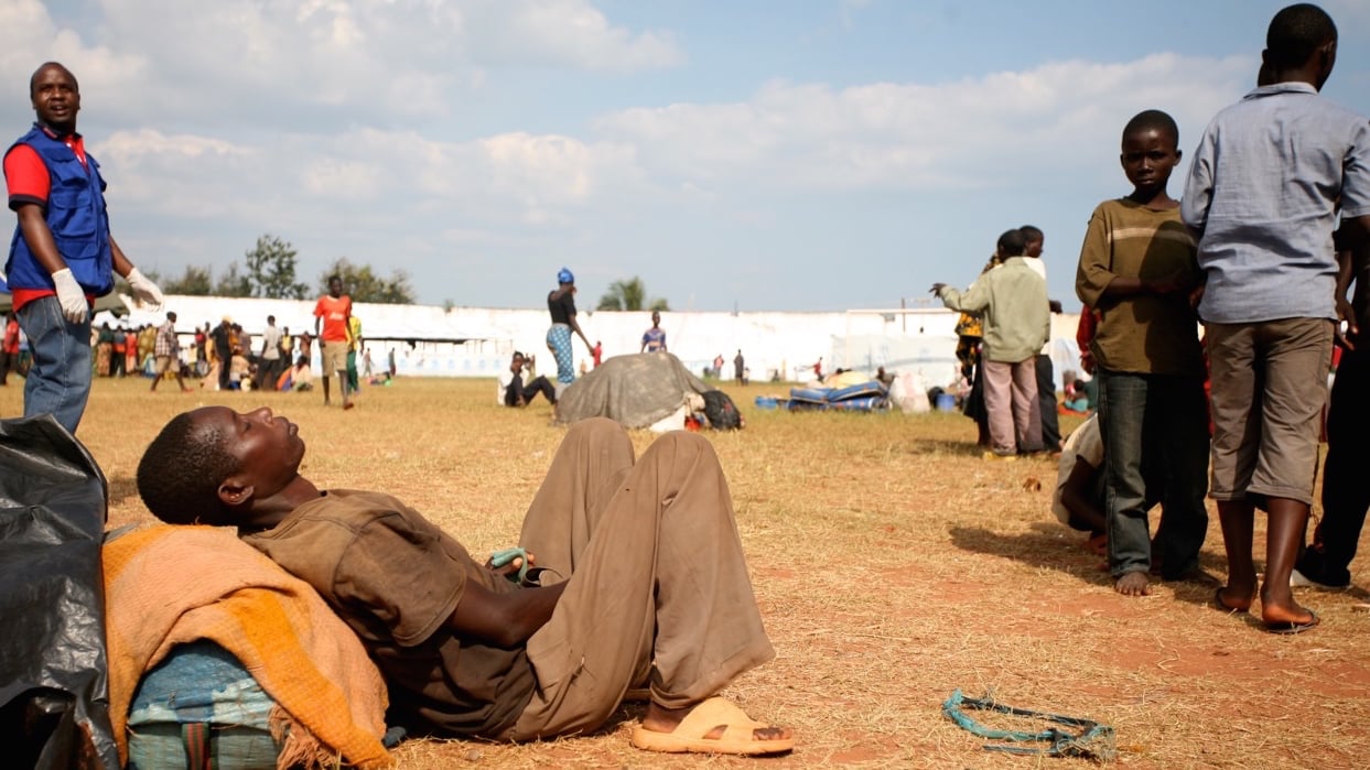 A Burundian refugee dozes in the midday sun at the Lake Tanganyika Stadium, a temporary transit camp for refugees in Kigoma, Tanzania. Tens of thousands of people have been fleeing Burundi amid rising political tensions and a failed coup ahead of election