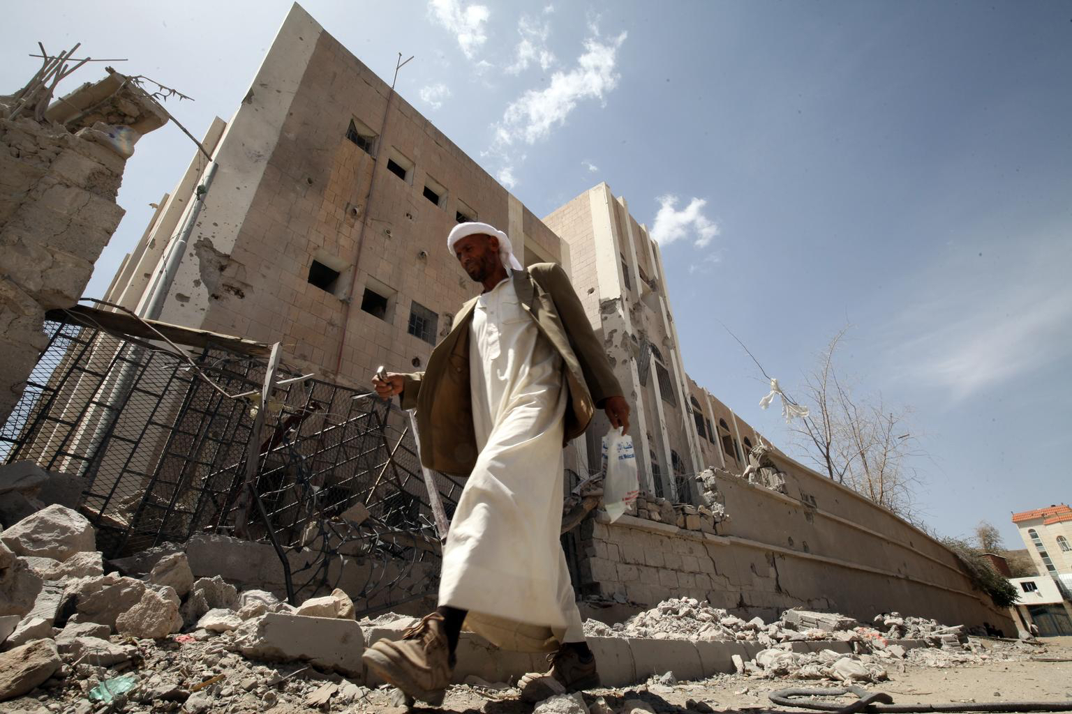 April 28, 2015. A guard walks past what remains of Ibn Sina School, in Sana’a, the capital. The school was heavily damaged during an air strike that hit the building next to the school. The impact of the blast crumbled the outer wall of the schoolyard a