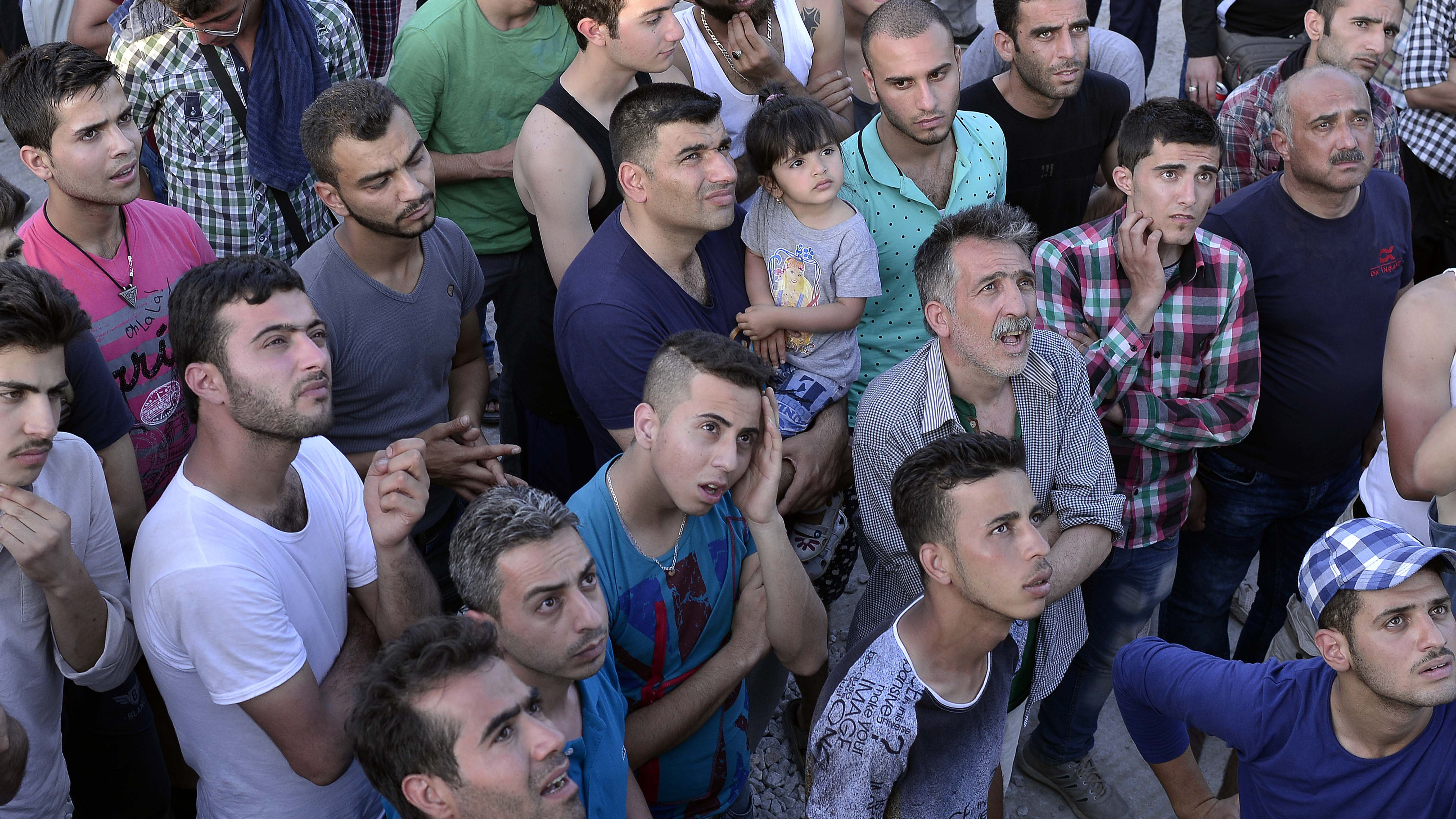 Migrants gather outside the identification centre at Moria on Greece's Lesvos Island to hear the names of the lucky few who will be accommodated inside. The rest will have to sleep in a makeshift camp outside.