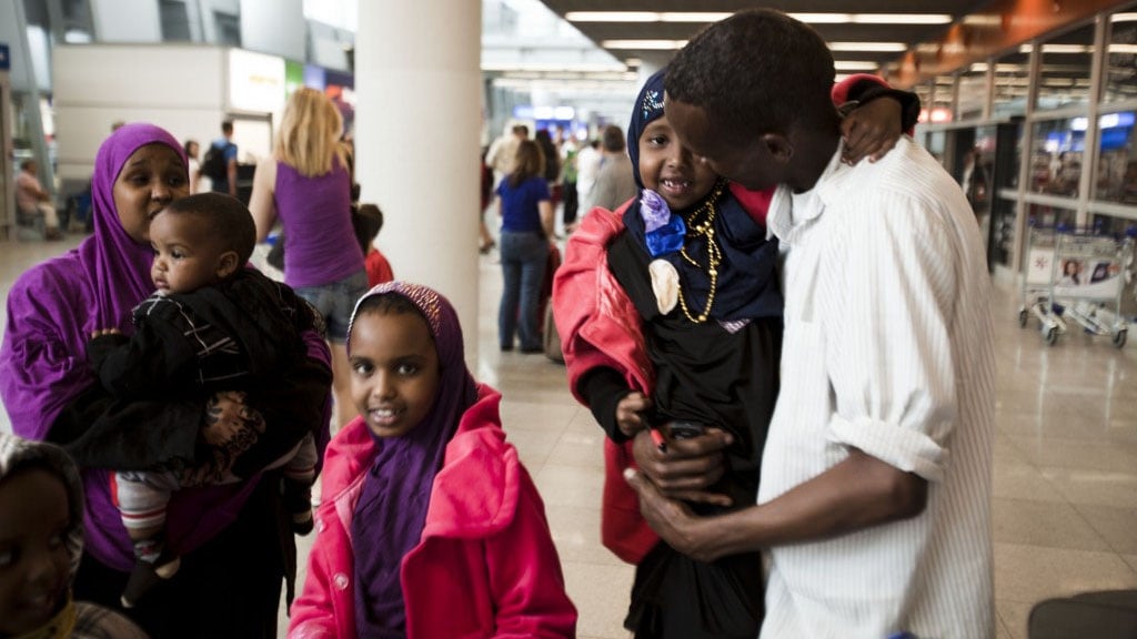 Mohad, a Somali refugee, reunites with his wife and children at Warsaw airport in Poland after five years apart