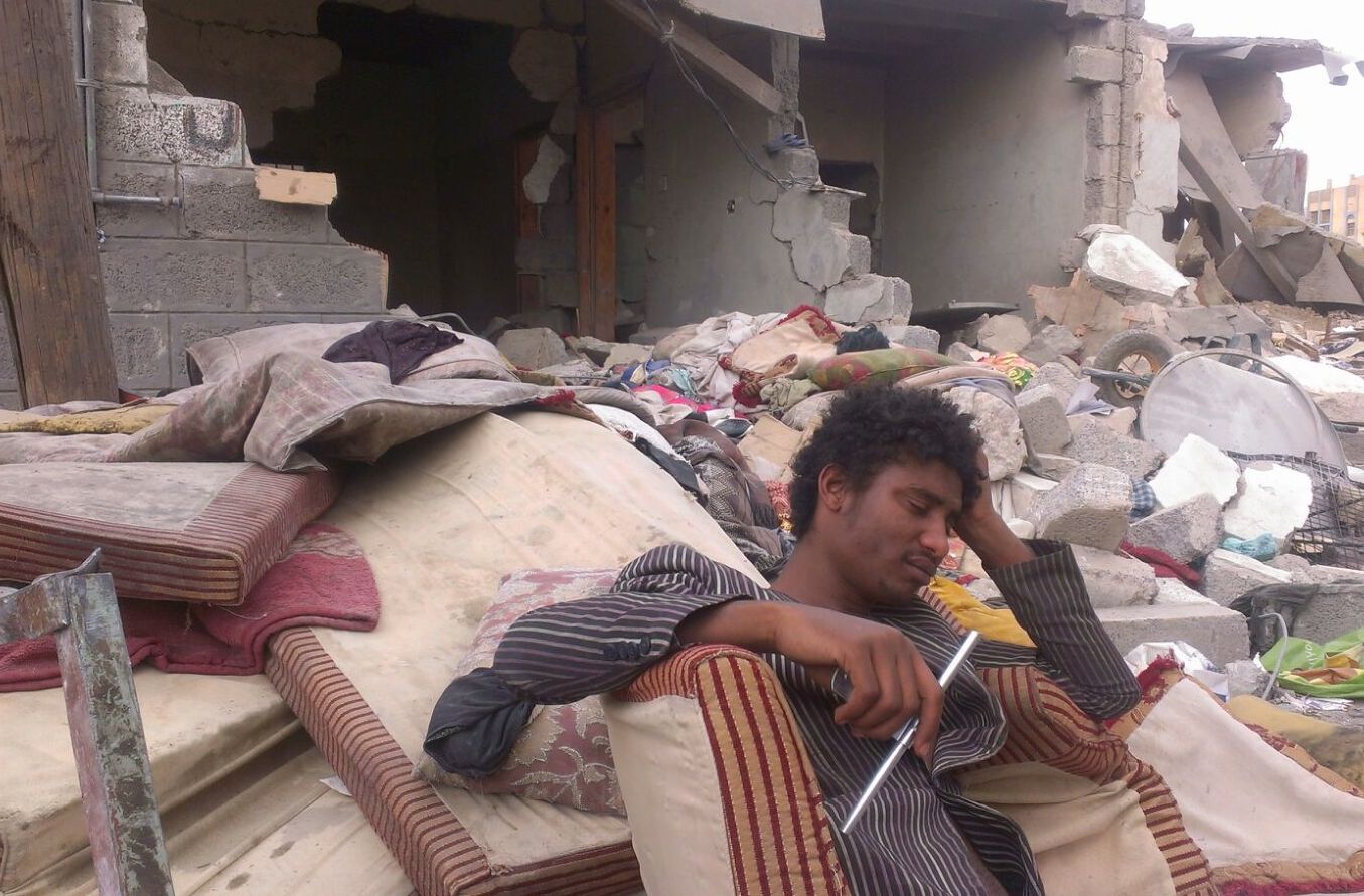 A Yemeni man sits outside the ruins of his home which was destroyed in an airstrike by the Saudi Arabian-led coalition