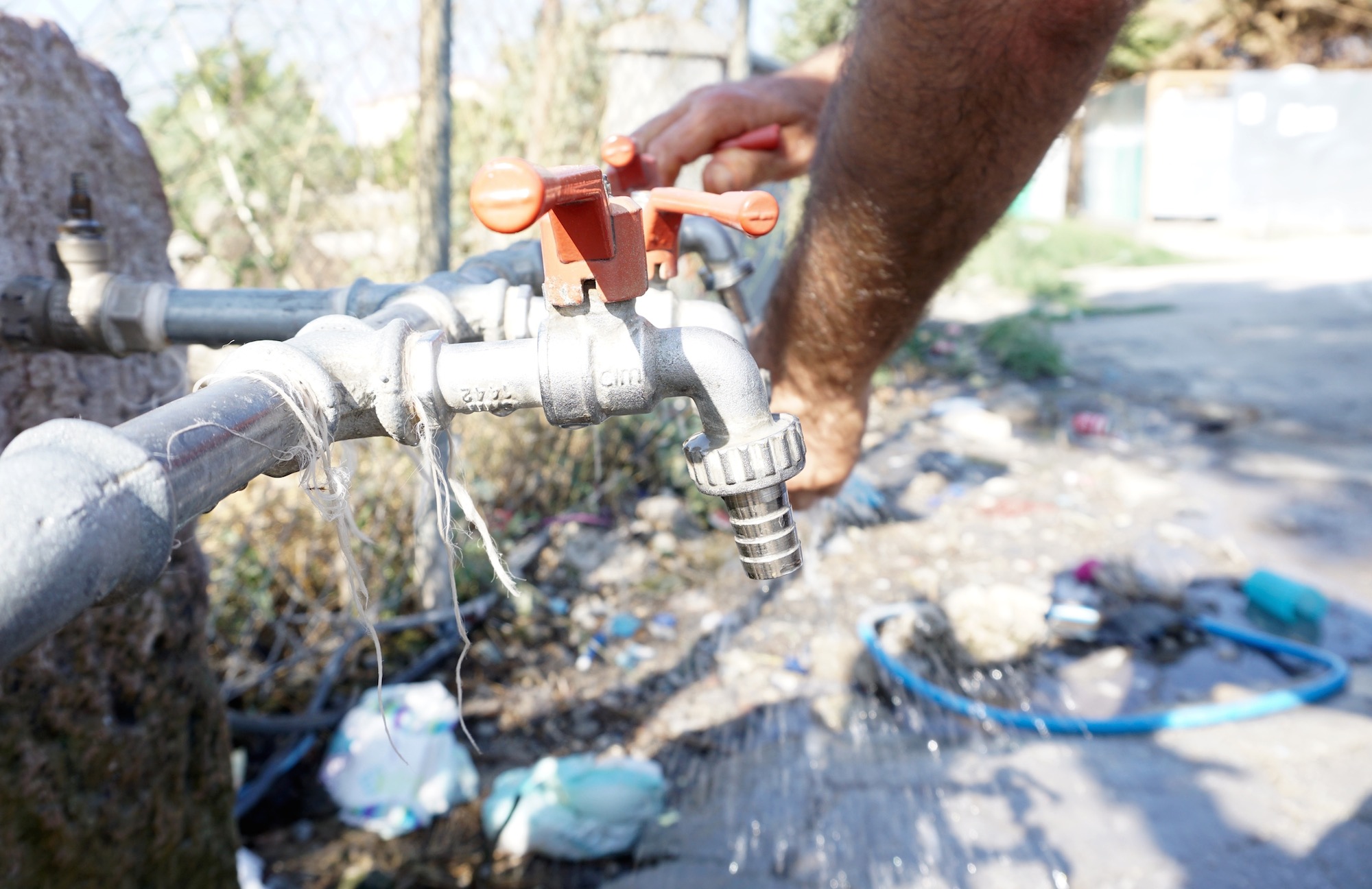 A refugee washes their hands at a makeshift camp on the Greek island of Lesbos