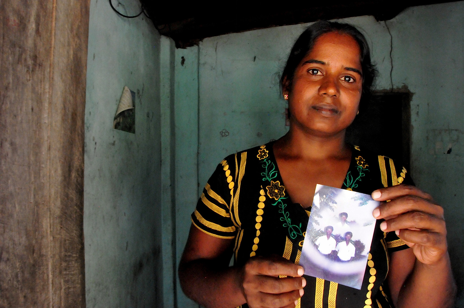 Vijitha Pavanendran holds a photo of her husband who was killed by unknown attackers during Sri Lanka's civil war