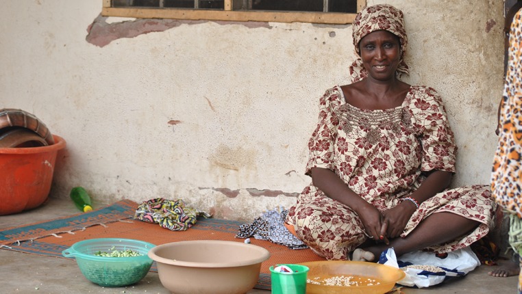 Aisha sits in front of her house in Yola, preparing dinner for her children and the host family. She has fled Borno almost a year ago when her village was attacked by Boko Haram militants.