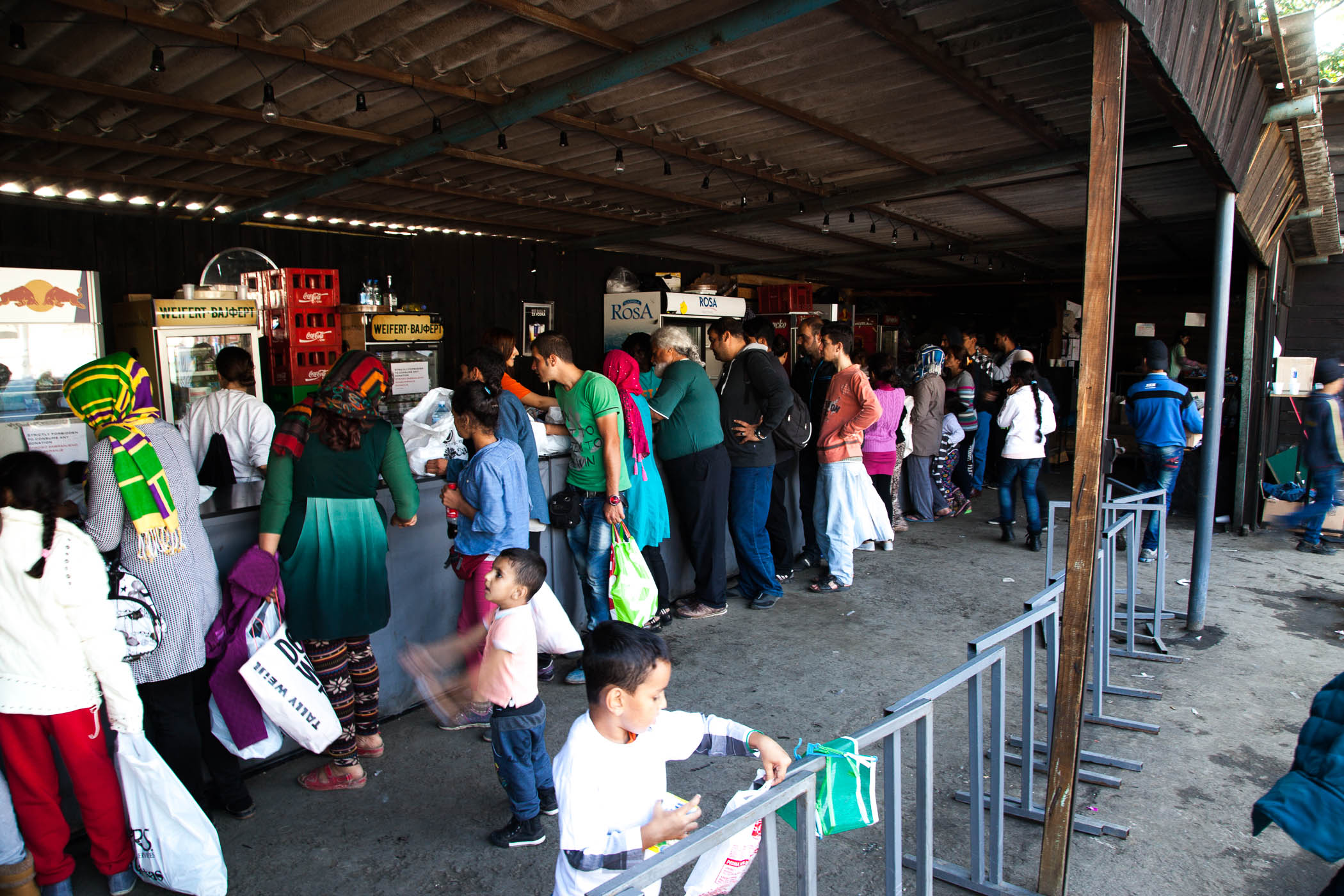 Refugees and migrants queue for food at Miksaliste, a hub for the refugee response in Belgrade, started by Refugee Aid Serbia, an umbrella group of local charities