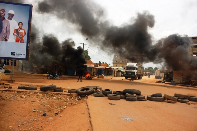 Protesters burn tires on roads to stop the military from passing in Ouagadougou
