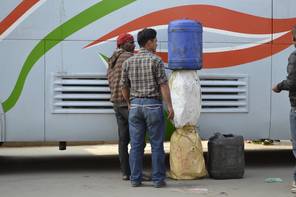 Men in Nepal's capital, Kathmandu, unload fuel smuggled over the border from India on a bus in January 2016