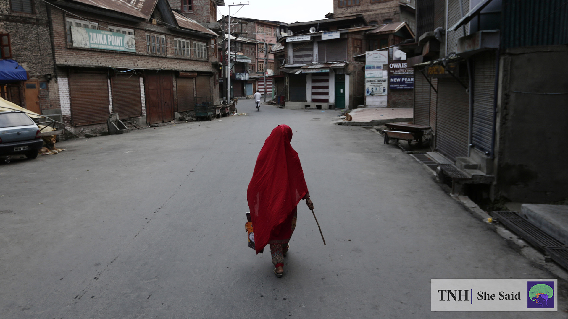 A Kashmiri woman walks through a deserted lane