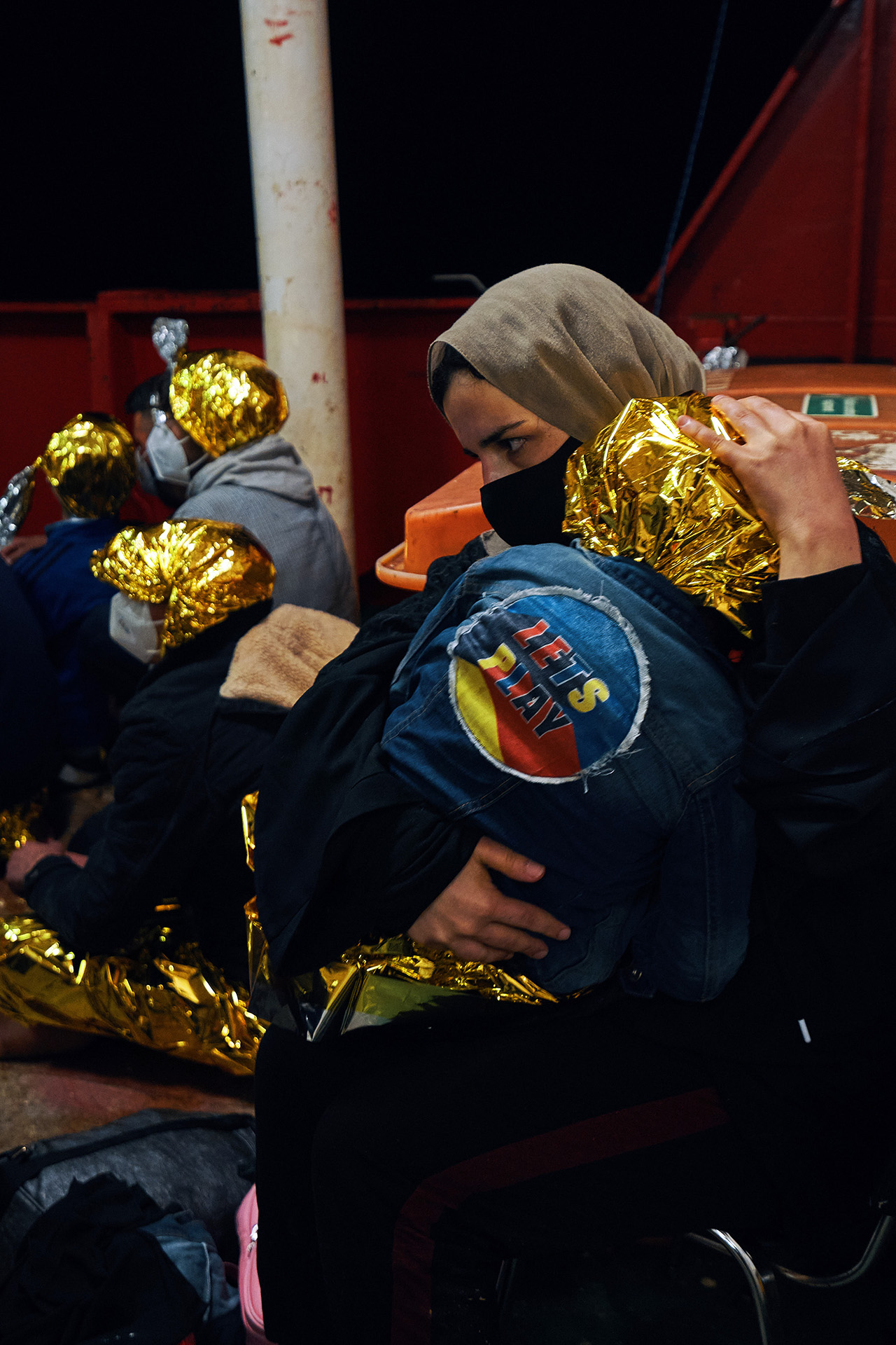 An asylum seeker rescued by Sea-Eye in the early morning hours of 17 May holds her child. The two were pulled out of a crowded wooden boat.
