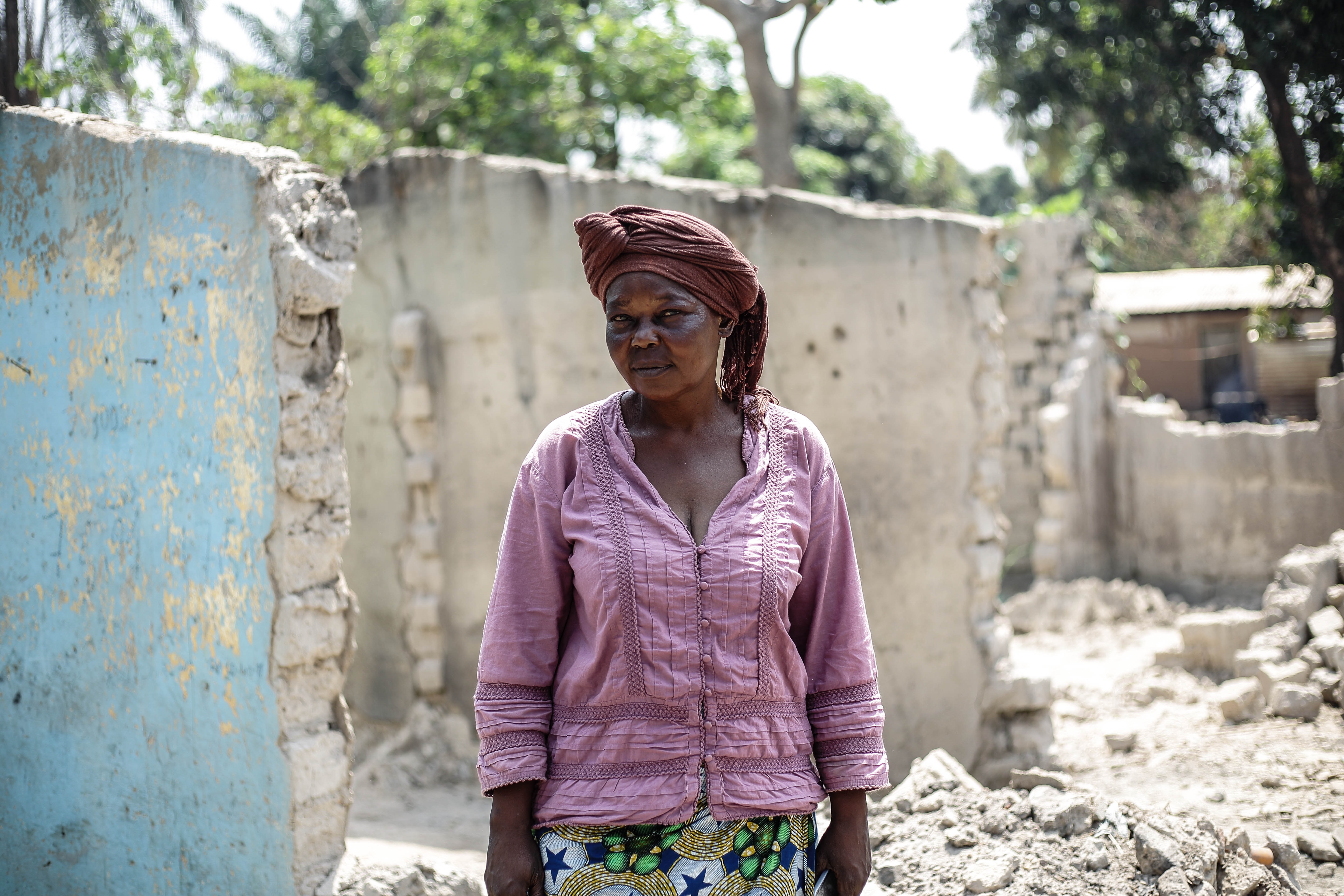 Melanie Ouagram stands outside her destroyed home in Fondo