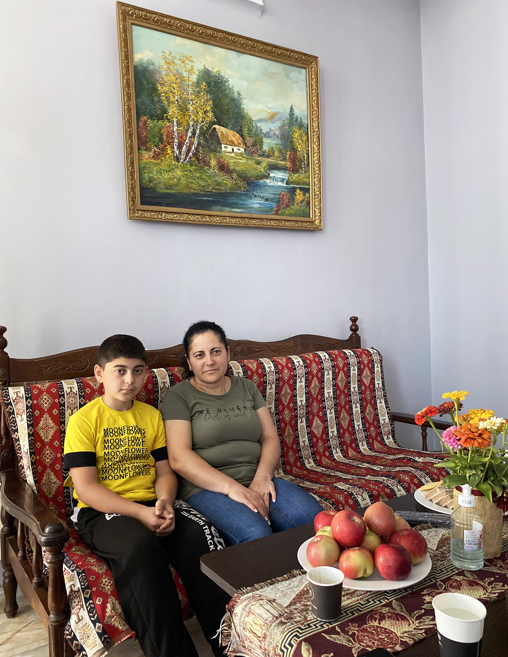 Lilit Dolukanyan and her son Alexey sit on a couch at a hotel in Yerevan for displaced families from Nagorno-Karabakh.