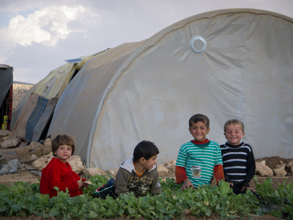 Yazidi children in front of a small garden on top of Mount Sinjar