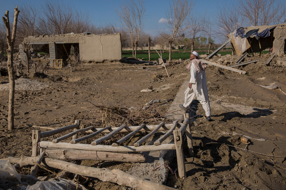 A man walks among destroyed homes